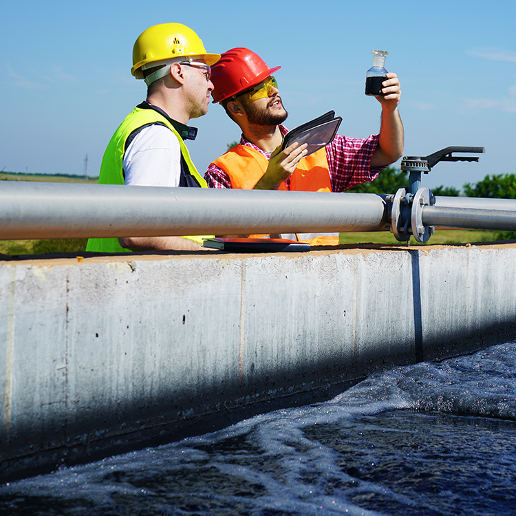 Engineers controlling a quality of water ,aerated activated sludge tank at a waste water treatment plant